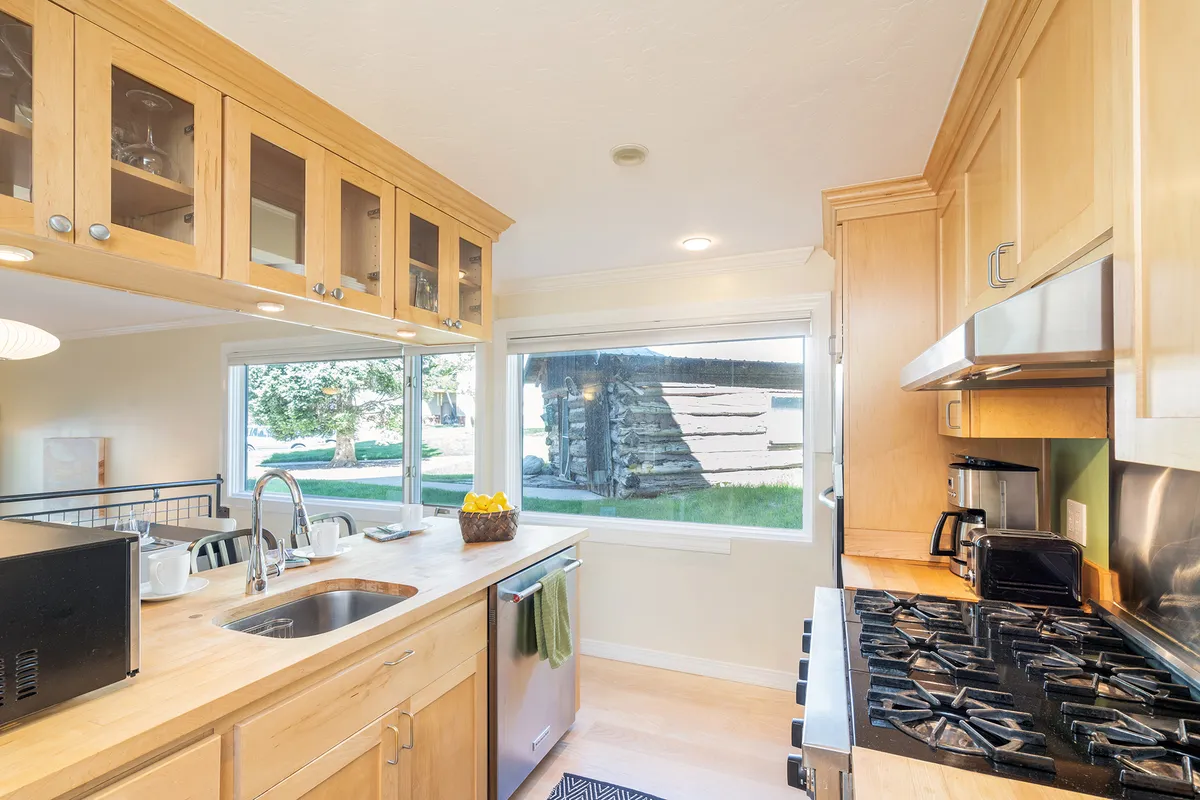 A welcoming kitchen interior with a large island, ample seating for gatherings, and a window view of green space outside. The scene invites togetherness, cooking, and family meals, echoing the text’s focus on convenience and comfort for families traveling with children.